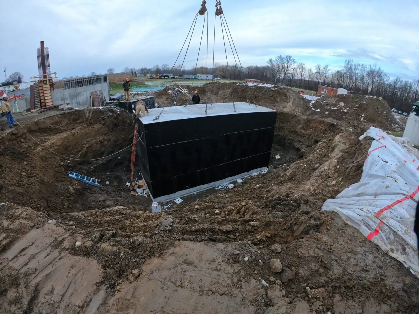 Concrete vault being lowered into a pit.
