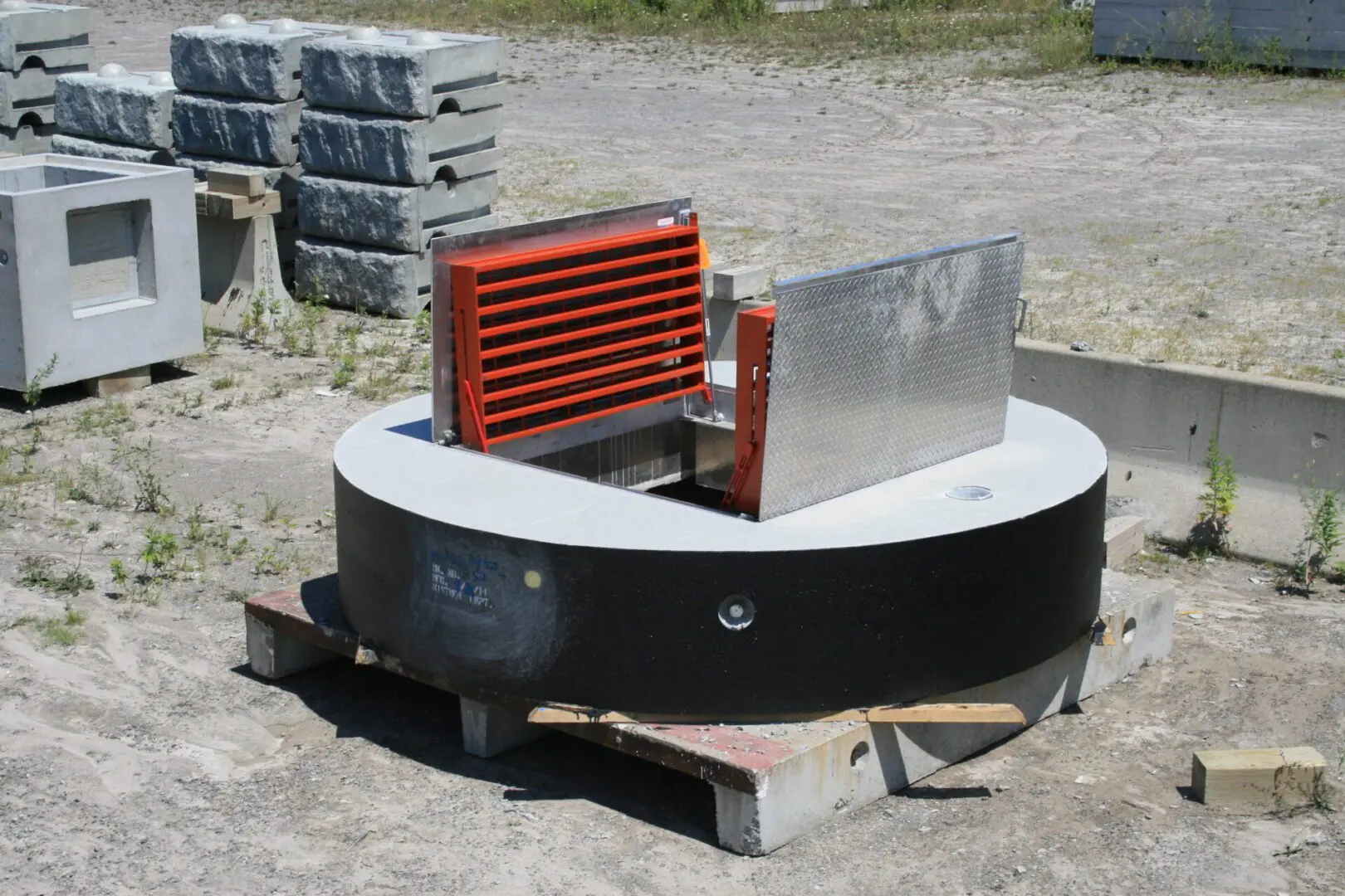 Concrete access cover with red grate.