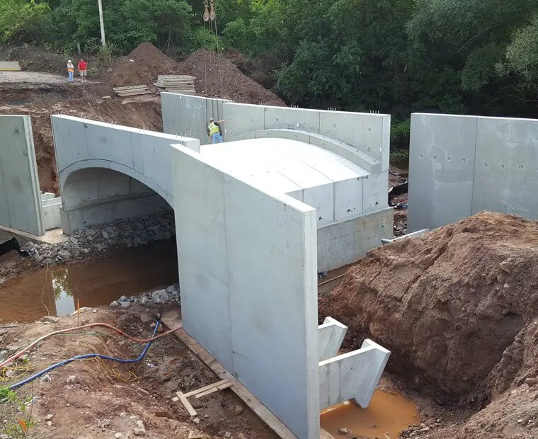 A bridge that is under construction with water coming out of it.