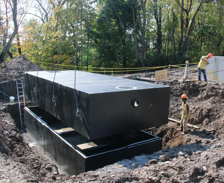 A large black box is being lifted into the ground.