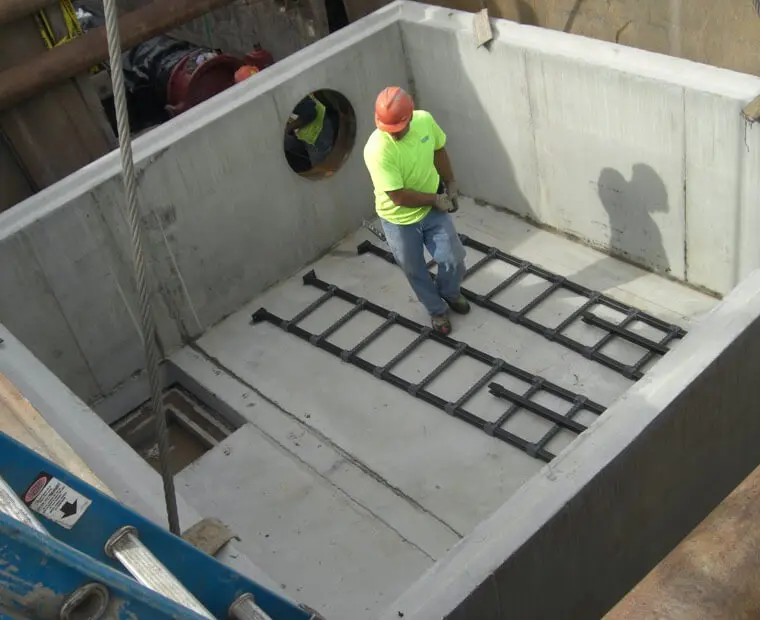 A construction worker standing on top of a concrete structure.